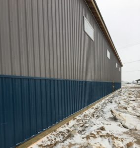 We finally have siding on our new building, complete with a blue trim along the bottom to match the blue roof!