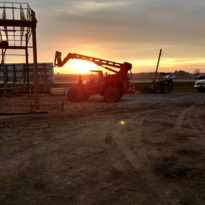 Workers at the Alt Oil Company jobsite capture a beautiful sunset behind a piece of machinery after a long day of work.